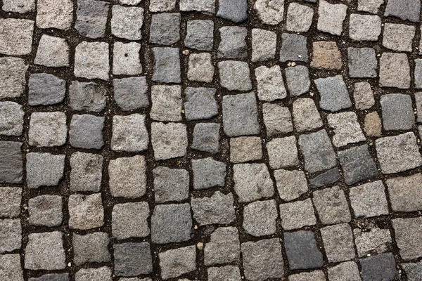 Mosaic of small marble cubes. sidewalks and squares formed by stone carpet with squares. Old cobblestones — Stock Photo, Image
