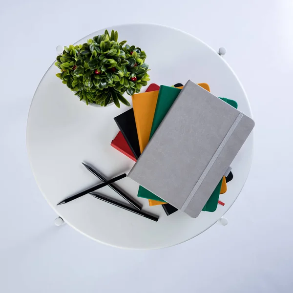 Stack Colourful Notebooks Pens White Table Plant Next Them Product Royaltyfria Stockfoton