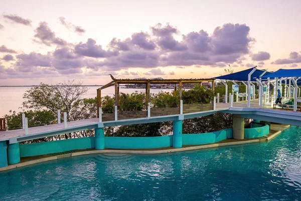 View of bridge over swimming pool and sea during sunset — Stock Photo, Image