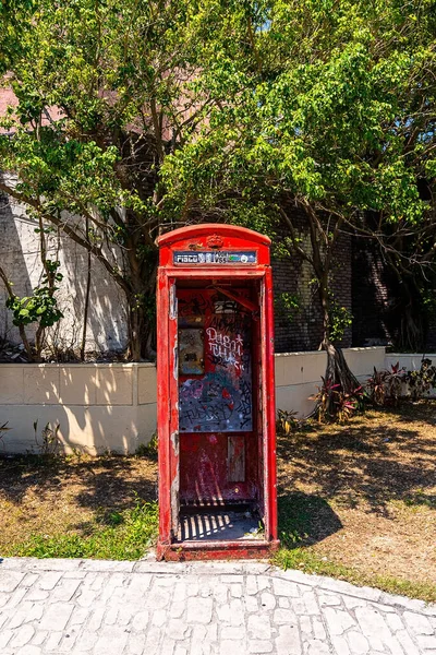 Cabine téléphonique rouge vandalisée sur la chaussée de la rue — Photo
