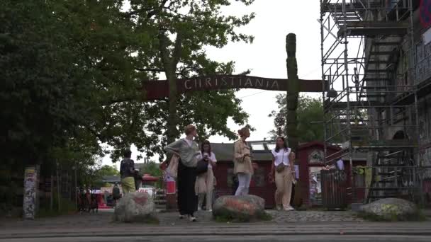 Señal de entrada al distrito de Christiania. Personas que entran en el país Christiania. — Vídeo de stock