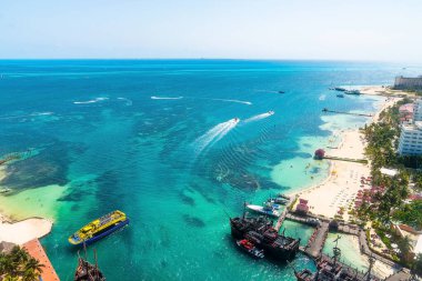 Cancun, Meksika. 30 Mayıs 2021. Korsan gemisi ve açık gökyüzüne karşı deniz yüzeyinde yüzen teknelerin manzarası.