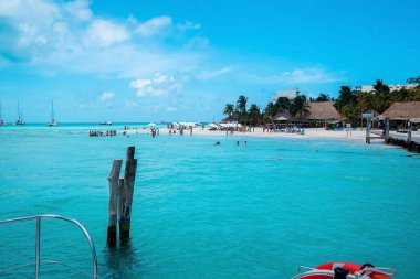 Cancun, Meksika. 30 Mayıs 2021. Tahta kale ve deniz rıhtımında turistler plajda tatilin tadını çıkarıyor, uzak diyarlarda yelkenliler