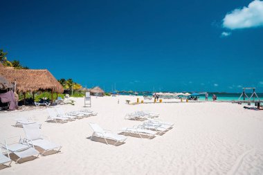 Cancun, Meksika. 30 Mayıs 2021. İskeleli kumsaldaki şezlonglar. Turistler yaz tatilinin tadını çıkarıyorlar. Uzaktaki tekneler