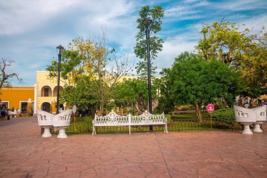 Cancun, Meksika. 30 Mayıs 2021. Kaldırımdaki boş koltuklar ve arka planda bina olan kamu parkı