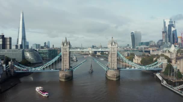 Letecký denní pohled na zvednutý Tower Bridge a projíždějící jachtu.