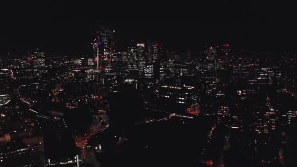Вид с воздуха на подсвеченный Тауэрский мост и панорамный вид Лондона ночью, Великобритания. — стоковое видео