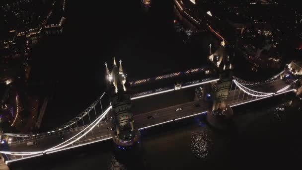 Widok z powietrza na oświetlony Tower Bridge i panoramę Londynu w nocy, Wielka Brytania. — Wideo stockowe