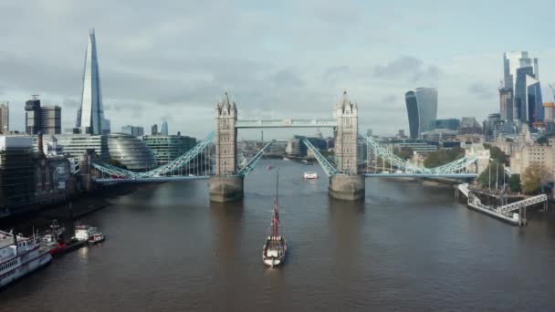 Flygfoto dagtid till den upplyfta Tower Bridge och yacht går igenom det. — Stockvideo