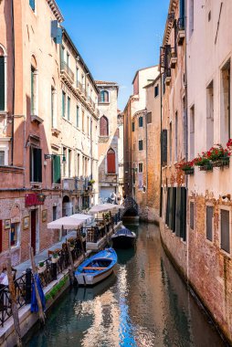 Konut binaları arasındaki dar kanalda yelkenli.