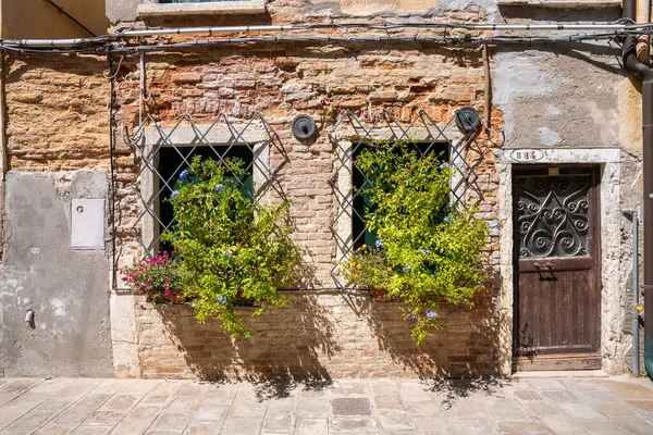 Gesloten deur van oude verweerde bakstenen muur woonhuizen — Stockfoto