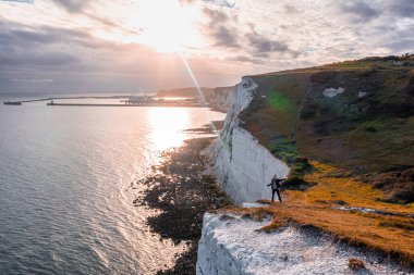 Dover 'ın Beyaz Kayalıkları' nın tepesinde duran genç adam.