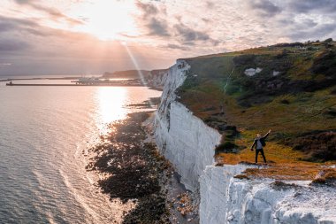 Dover 'ın Beyaz Kayalıkları' nın tepesinde duran genç adam.