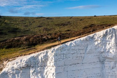 Dover 'ın Beyaz Kayalıkları' nın tepesinde duran genç adam.