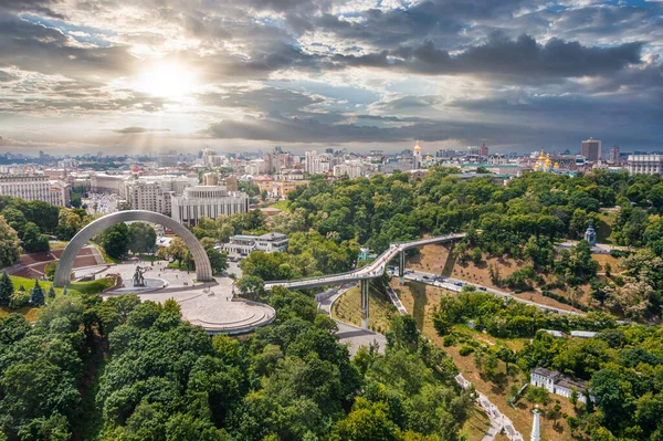 Coucher de soleil sur l'été Kiev avec l'arche de l'amitié des peuples. — Photo