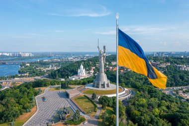 Ukrayna bayrağının rüzgarda dalgalanan havadan görünüşü Kyiv şehrine karşı