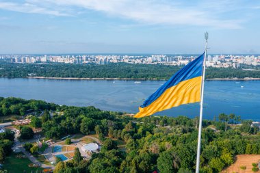 Ukrayna bayrağının rüzgarda dalgalanan havadan görünüşü Kyiv şehrine karşı