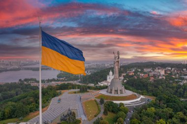 Ukrayna bayrağının rüzgarda dalgalanan havadan görünüşü Kyiv şehrine karşı