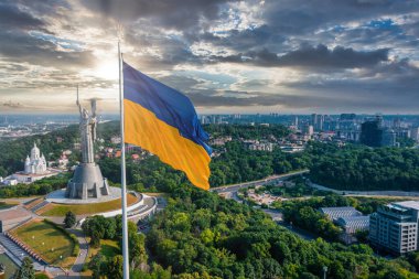 Ukrayna bayrağının rüzgarda dalgalanan havadan görünüşü Kyiv şehrine karşı