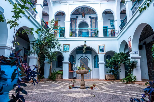 Fountain and pot plants in courtyard of traditional house building — Stockfoto