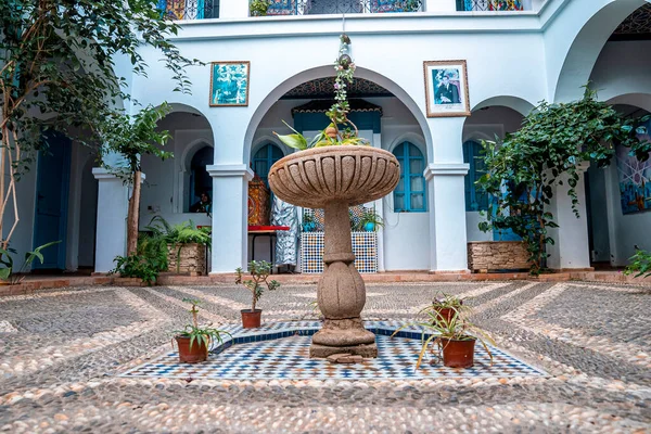 Fountain and pot plants in courtyard of traditional house building — Fotografia de Stock