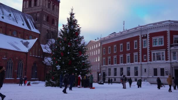 Άγιος Βασίλης με τα πόδια από το τεράστιο χριστουγεννιάτικο δέντρο στη Ρίγα, Λετονία. — Αρχείο Βίντεο