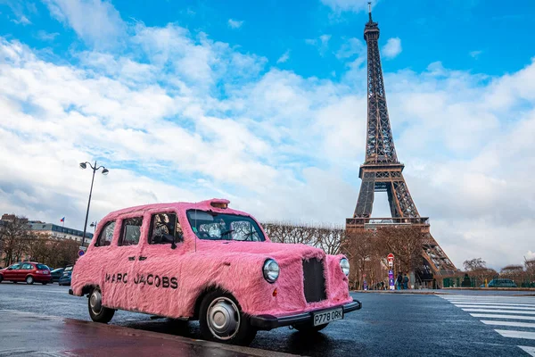 Coche rosa divertido Marc Jacobs estacionado en París con la torre Eiffel en el fondo. — Foto de Stock