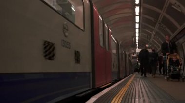 Londra metro istasyonu. Platformda hareket eden ağır çekim treni.