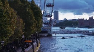 İnsanlar Londra Göz dönme dolabının yanında yürüyorlar.