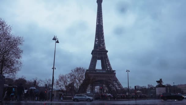 Regendag in Parijs met mensen die onder de regen lopen in de buurt van de Eiffeltoren. — Stockvideo