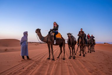 Bedeviler çölde turistlerle dolu bir kervana önderlik ediyor.