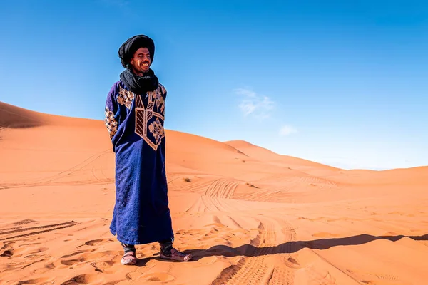 Bedouin man wears traditional clothes while standing in desert against sky — Zdjęcie stockowe