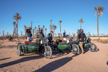 Group of people on retro motorcycle with sidecar during road trip