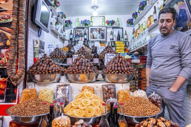 Vendor selling dates and dried fruits in the shop at marketplace