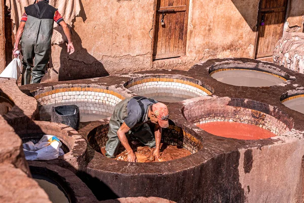 Man working as a tanner in the dye pots at tannery for traditional dyeing of leather — Stock Fotó