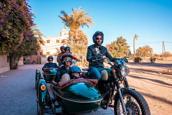 Group of people traveling on vintage motorcycle with sidecar — стокове фото