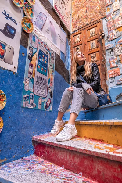 Curiosa turista femenina mirando algo interesante, carteles y marcos en la pared — Foto de Stock