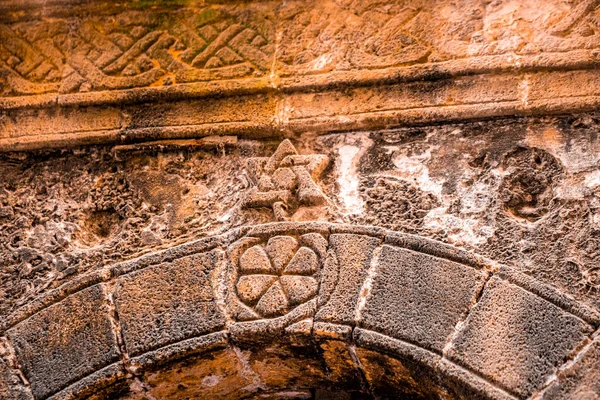 Close up of traditional carving on ancient weathered stoned wall — 스톡 사진