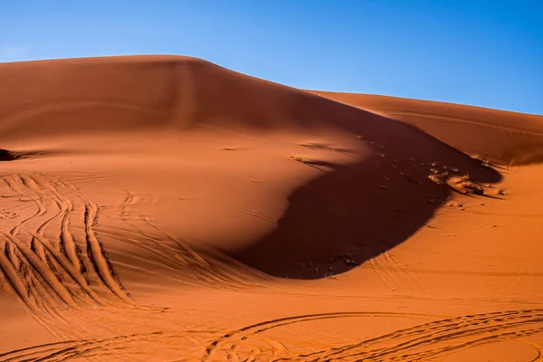 Sand dunes with tyre marks in desert on sunny summer day against sky — Foto Stock