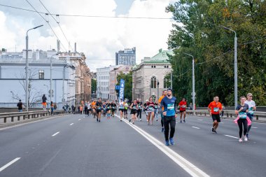 Tet Riga Maratonu sırasında Riga caddelerini geçen koşucular.