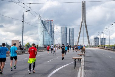Tet Riga Maratonu sırasında Riga caddelerini geçen koşucular.