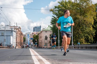 Tet Riga Maratonu sırasında Riga caddelerini geçen koşucular.