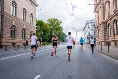 Tet Riga Maratonu sırasında Riga caddelerini geçen koşucular.
