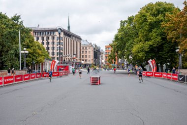 Tet Riga Maratonu sırasında Riga caddelerini geçen koşucular.