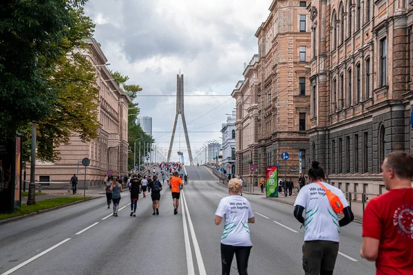 Løbere krydser Riga gader under Tet Riga Marathon. - Stock-foto