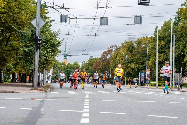 Løbere krydser Riga gader under Tet Riga Marathon. - Stock-foto
