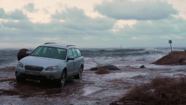 Bilen parkerad och fast vid havet stranden under kraftig storm — Stockvideo