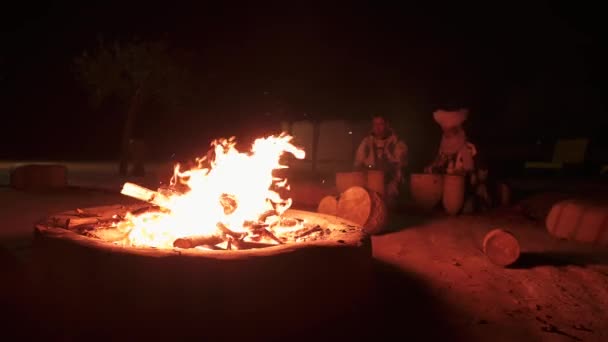 Dos hombres tocando la batería en fogata por la noche en el desierto del Sahara, Marruecos. — Vídeos de Stock