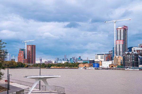 Barche al molo di fronte a gru di costruzione e edifici urbani — Foto Stock