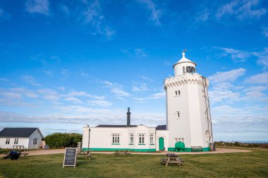 Güneşli bir günde mavi bulutlu gökyüzüne karşı beyaz trevose baş deniz feneri